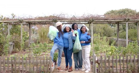 Diverse Community Garden Volunteers Harvesting Fresh Produce at Allotment Gate