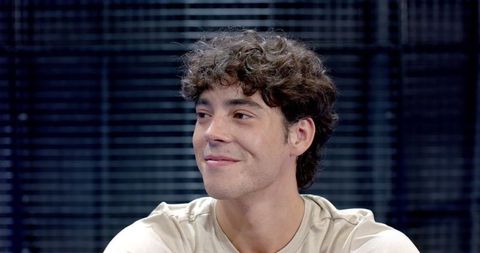 Smiling Man in Studio with Dark Slat Background