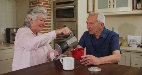Happy Senior Couple Enjoying Coffee in Modern Kitchen