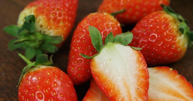 Fresh strawberries are displayed up close, showcasing their vibrant red color and juicy texture. These ripe berries are often associated with healthy eating and can be used in a variety of culinary dishes.