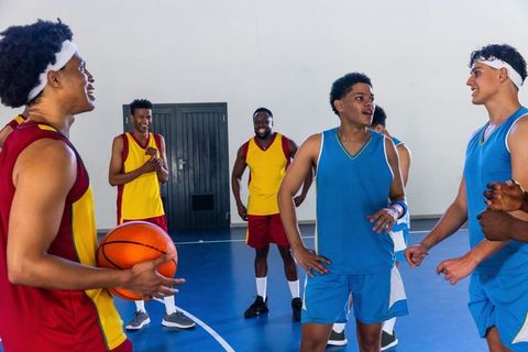 Diverse basketball team bonding during indoor practice