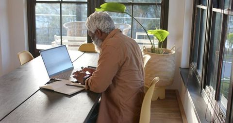 Senior professional working at laptop in modern workspace