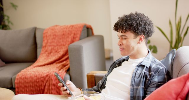 Young Man Relaxing on Couch Using Smartphone in Cozy Living Room - Download Free Stock Images Pikwizard.com