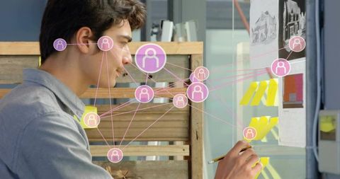 Designer organizing yellow sticky notes on glass board visualizing digital collaboration