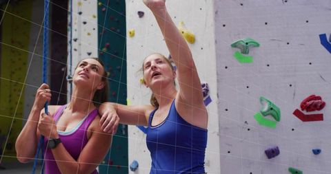 Instructor Coaching Climber on Indoor Climbing Wall for Fitness Training