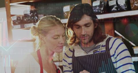 Inspecting inventory using tablet with sales analytics overlay in artisanal grocery shop