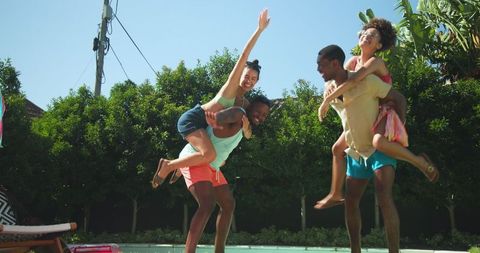 Diverse Couples Enjoying Piggyback Fun by Poolside in Summer Wear