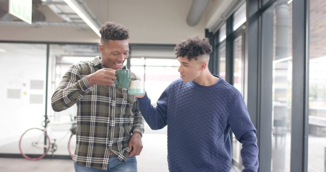 Two Young Men Socializing While Drinking Coffee in Modern Office Space - Download Free Stock Images Pikwizard.com