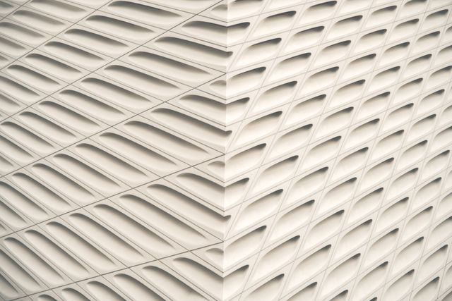 Abstract close-up of a modern building facade with white wavy patterns creating a geometric, minimalistic design. Useful for architectural firms, design inspiration in urban planning, artistic backgrounds, and presentations showcasing innovative building techniques.