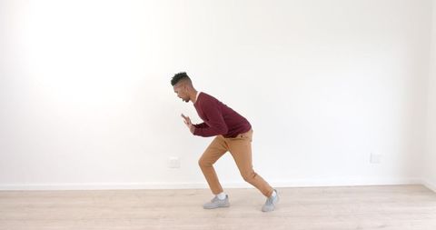 Young Man Practicing Dance Moves in Empty Room