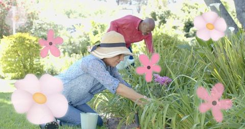 Sunlit backyard couple tending flower bed kneeling gardener in straw hat with watering can