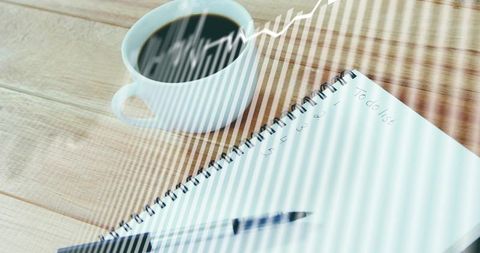 Morning productivity planning with coffee, spiral notebook and pen under striped sunlight