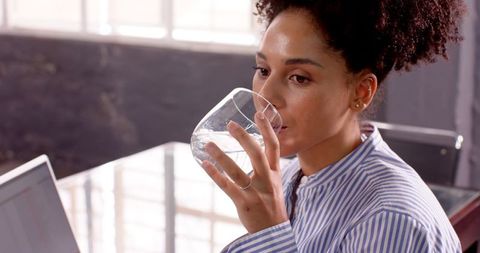 Young Professional Woman Staying Hydrated in Office