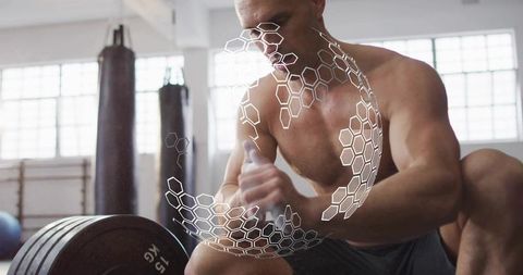 Shirtless athlete chalking hands before heavy barbell lift with 15 kg plates