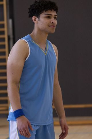 Confident Male Athlete in Blue Basketball Gear on Indoor Court