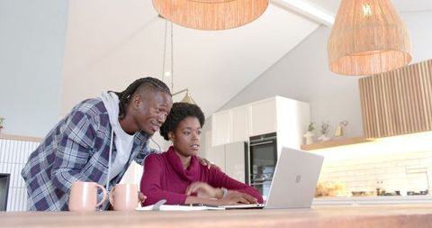 Couple Collaborating on Laptop in Cozy Kitchen Setting