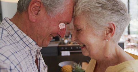 Senior couple sharing intimate moment in bright kitchen