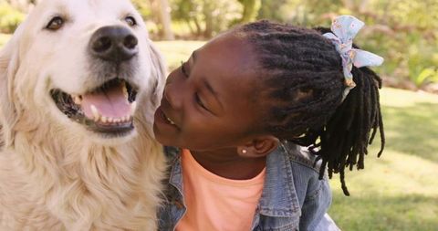Joyful Child Bonding with Golden Retriever in Sunny Park
