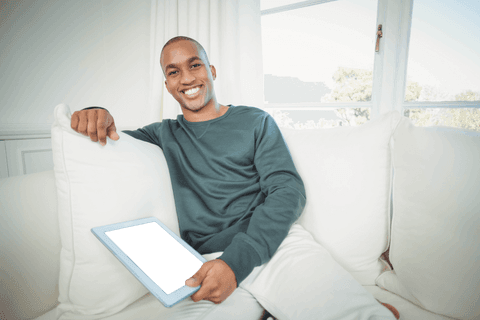 Transparent Background: Smiling Man with Tablet on Sofa at Home