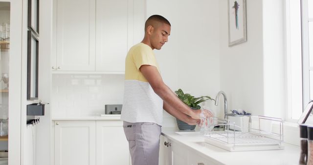 Focused Young Man Washing Dishes in Modern White Kitchen - Download Free Stock Images Pikwizard.com