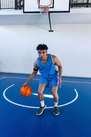 Teen Basketball Player Dribbling in Indoor Gym