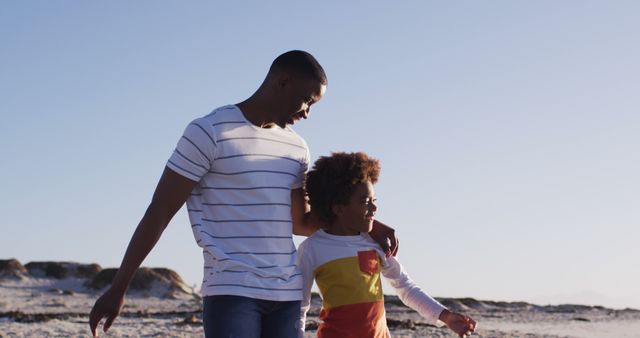 African american father and son enjoying the view while standing the beach. family travel vacation leisure concept