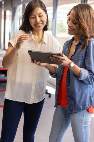 Diverse Female Colleagues Communicating with Tablet