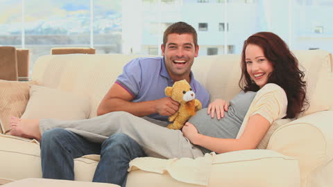 Happy Expecting Couple Enjoying Time Together on Cozy Couch