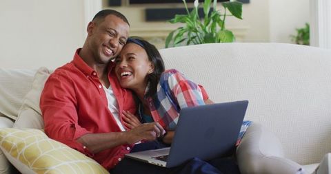 Loving Mixed Race Couple Relaxing Embracing While Using Laptop
