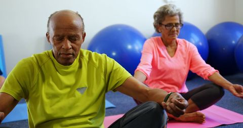 Senior Couple Practicing Yoga with Blue Exercise Balls