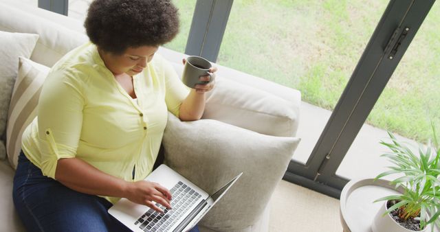 Woman Enjoys Coffee While Working on Laptop at Home - Download Free Stock Images Pikwizard.com