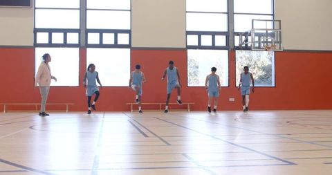Basketball team warm-up drills in school gymnasium