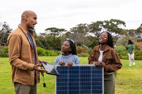 African american family installing solar panels in park showcasing renewable energy