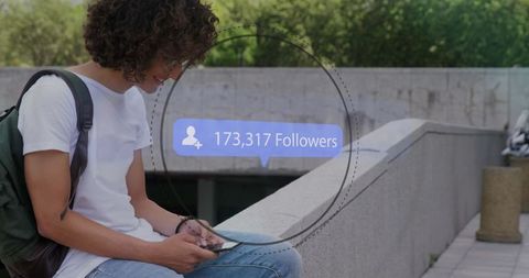 Young man seated outdoor checking social media follow count