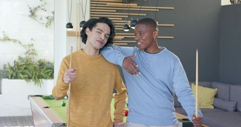 Multiracial friends playing pool in modern game room casual leisure and friendship