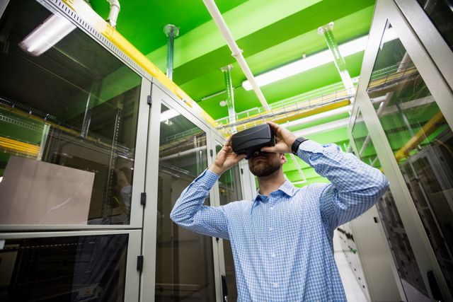 Technician using virtual reality headset in server room, showcasing modern technology and innovation in IT industry. Ideal for illustrating concepts of digital transformation, network infrastructure, and futuristic technology in professional environments.