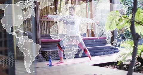 Man practicing yoga on outdoor deck holding warrior pose with world map overlay