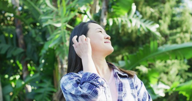 Image of happy asian woman in sunlight in garden. Leisure and spending time at home and garden concept digitally generated image.