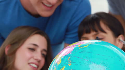 Excited Students Exploring World Continents on a Globe