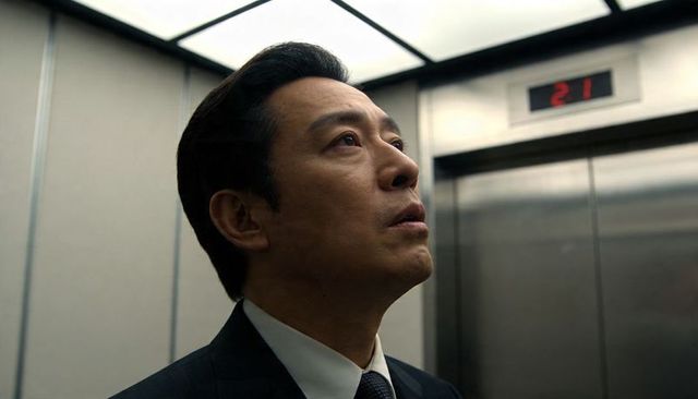 Middle-aged Asian Executive Looking Up in Elevator, Tense Corporate Portrait, Floor 21