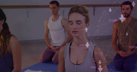 Meditating woman practicing mindfulness in yoga class with digital wellness data overlay