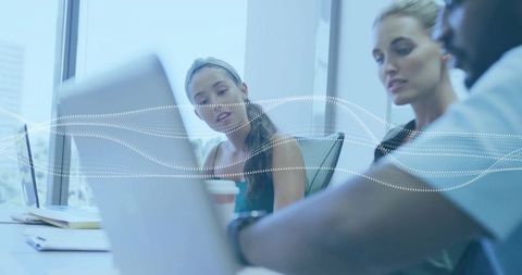 Team collaboration on project with data overlay in modern office