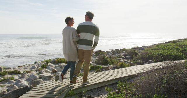 Middle-Aged Couple Walking Along Beach Boardwalk - Download Free Stock Images Pikwizard.com