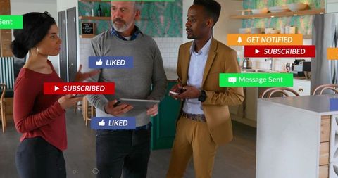 Coworking team discussing social media alerts while holding tablet and smartphones