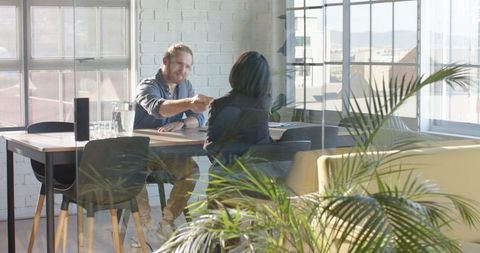 Diverse Business Professionals Sealing Partnership in Modern Office