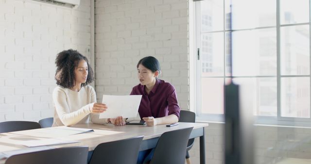 Two Businesswomen Reviewing Documents in Bright Modern Office - Download Free Stock Images Pikwizard.com