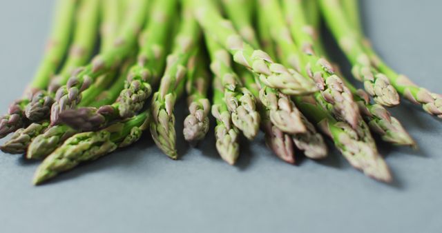 Image of close up of fresh asparagus over grey background. fusion food, fresh vegetables and healthy eating concept.