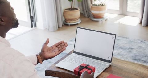 Remote celebration with virtual gift - man gesturing at laptop screen