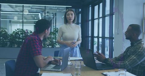 Asian Woman Leading Team Meeting in Modern Office Conference Room