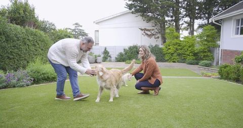 Joyful Couple Bonding with Dogs in Green Backyard
